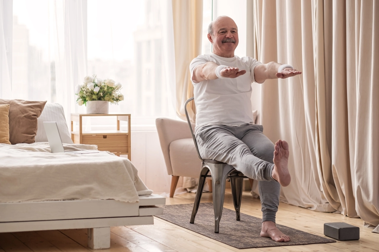 Older man exercising in a cozy bedroom