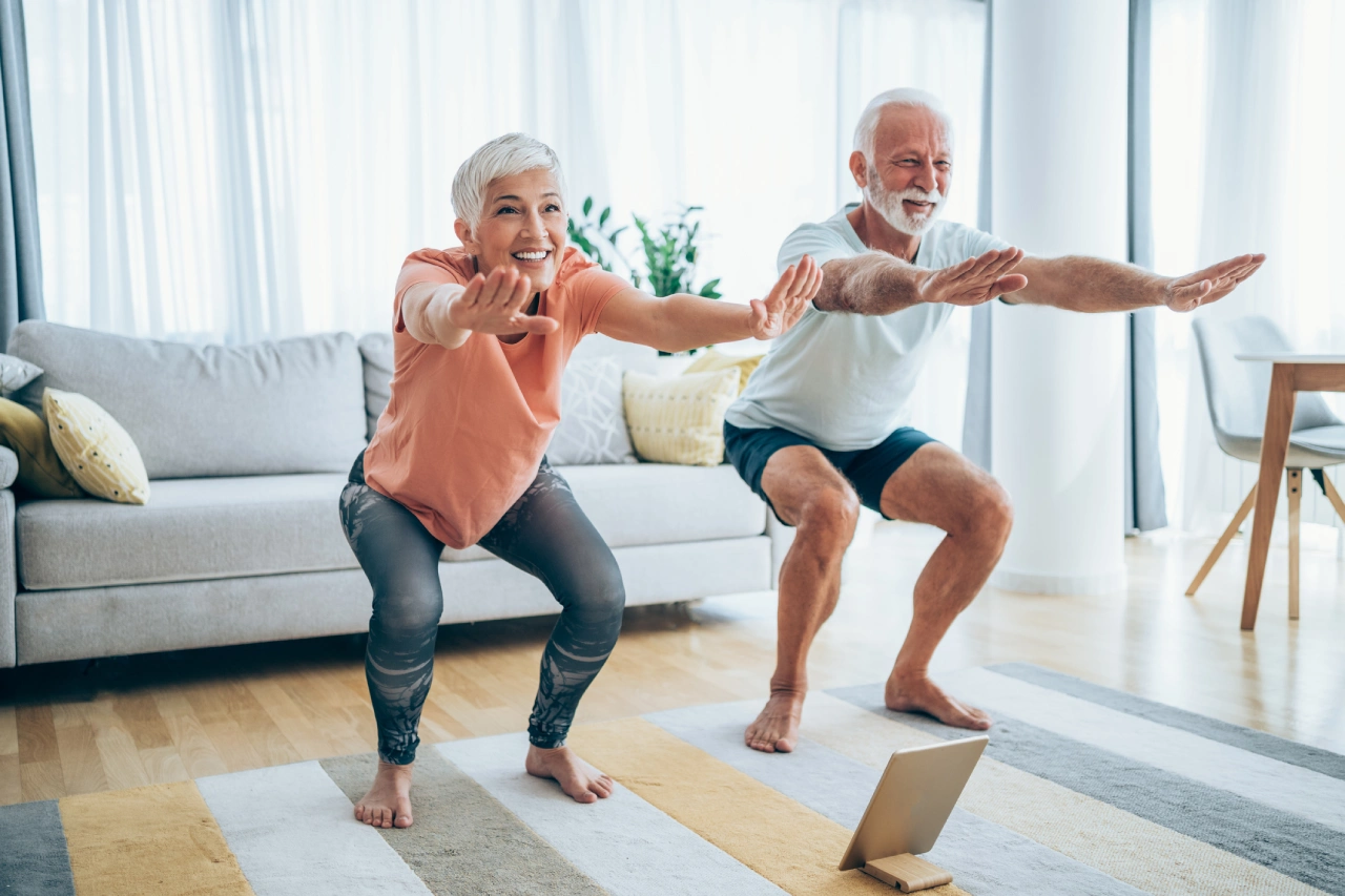 Elderly couple exercising together at home